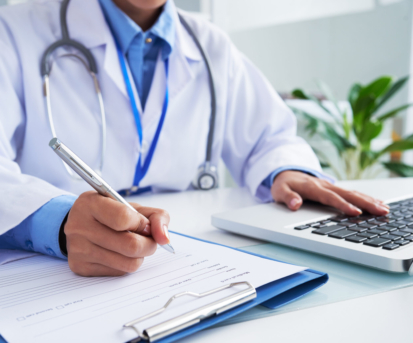 Doctor checking information in computer program before filling medical card